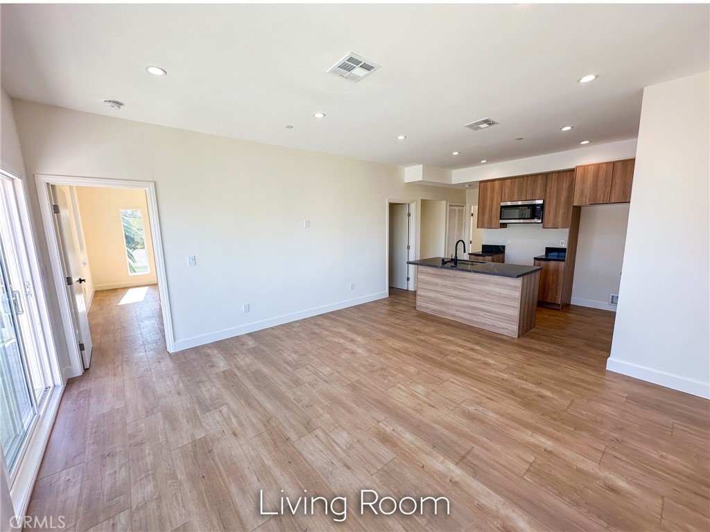 a view of a kitchen with furniture and wooden floor