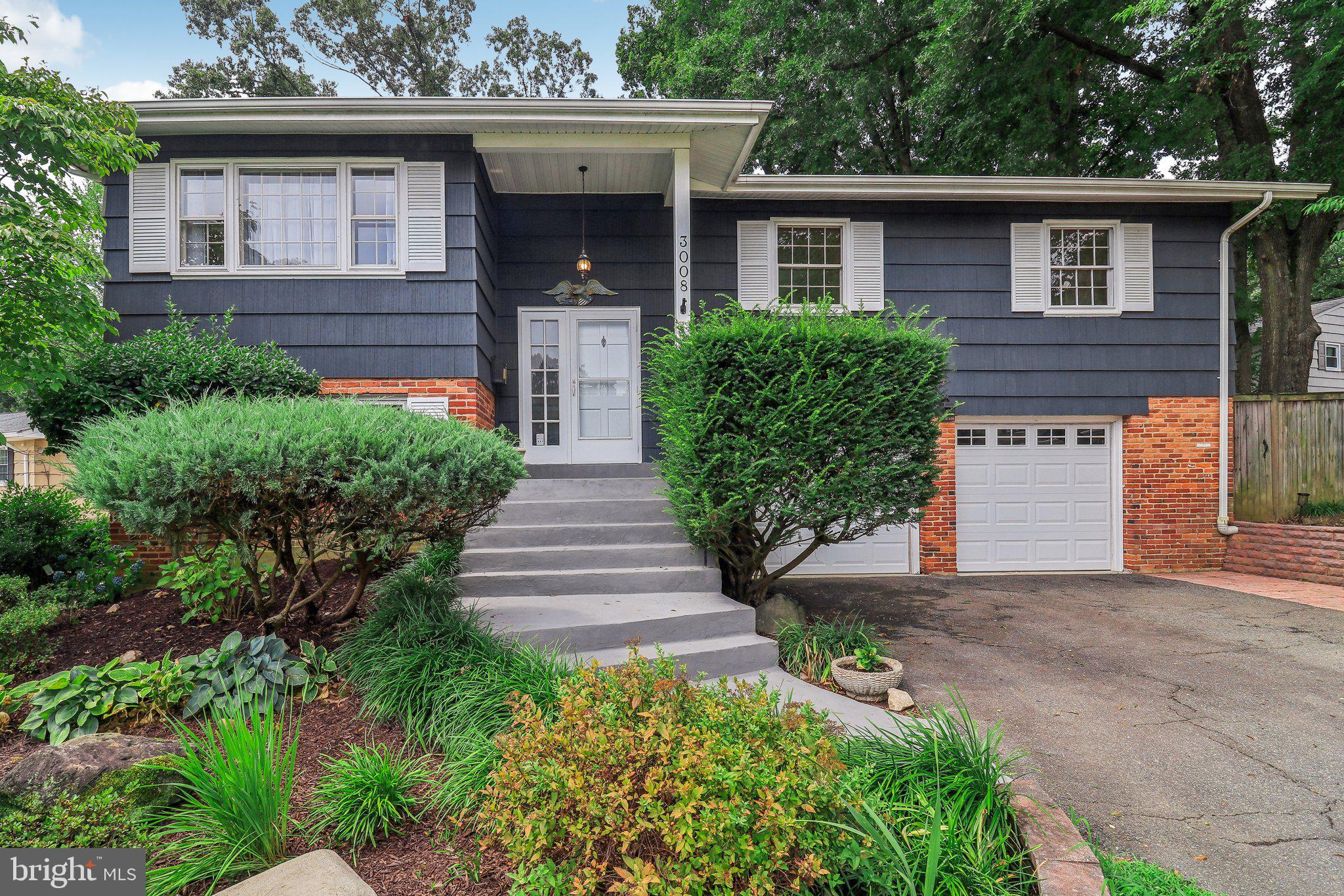 a front view of a house with a yard and trees