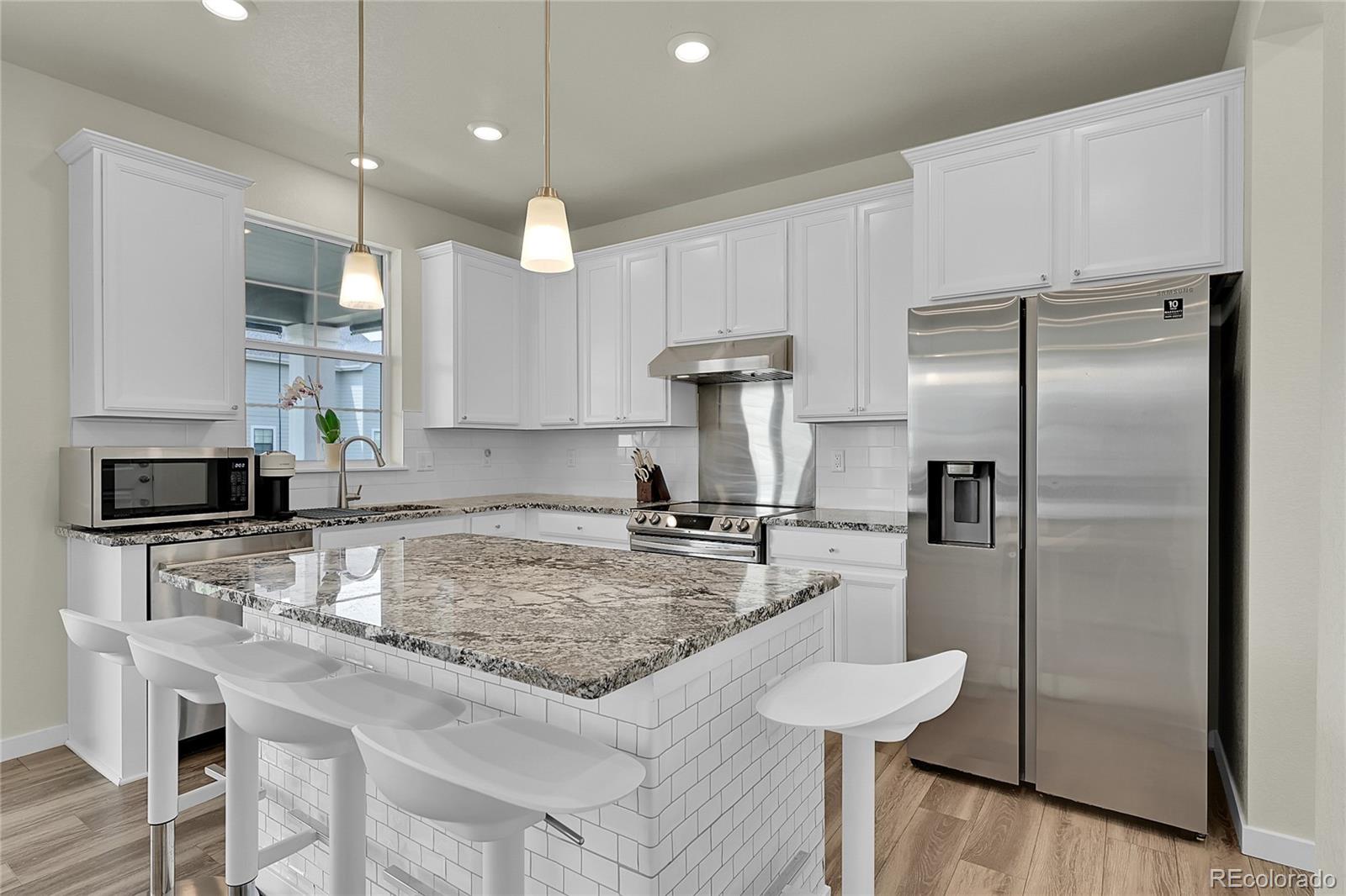 a kitchen with kitchen island a counter space a sink appliances and cabinets