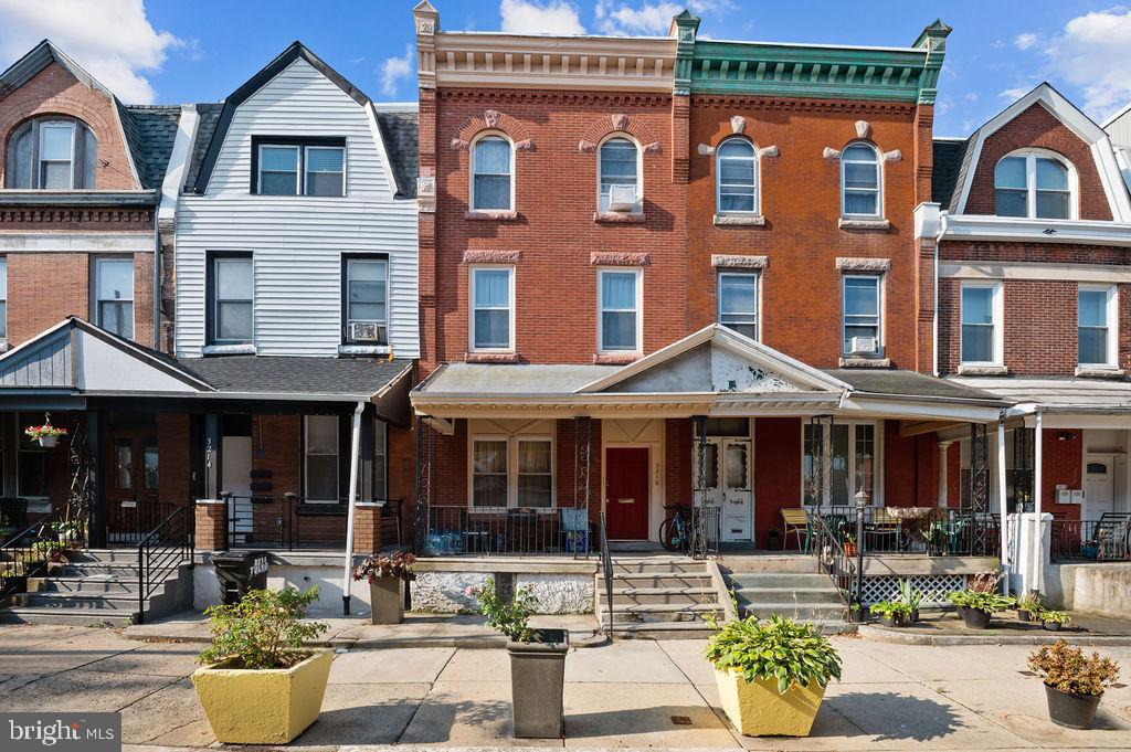 a front view of a building with outdoor seating and a potted plant