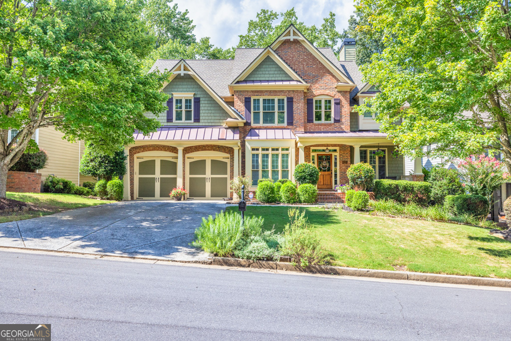 a front view of a house with a yard and potted plants