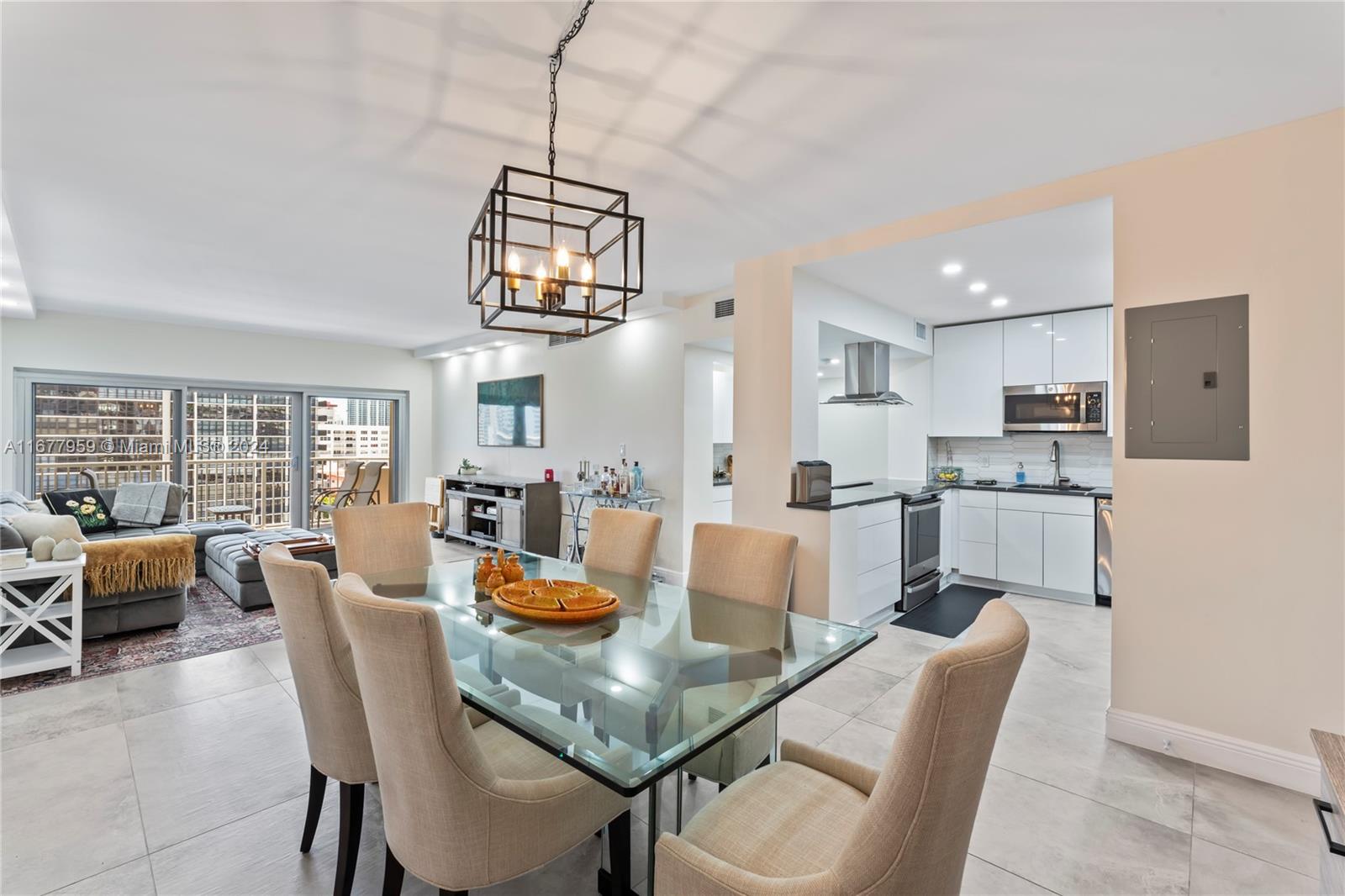 a view of a dining room and livingroom with furniture wooden floor a chandelier