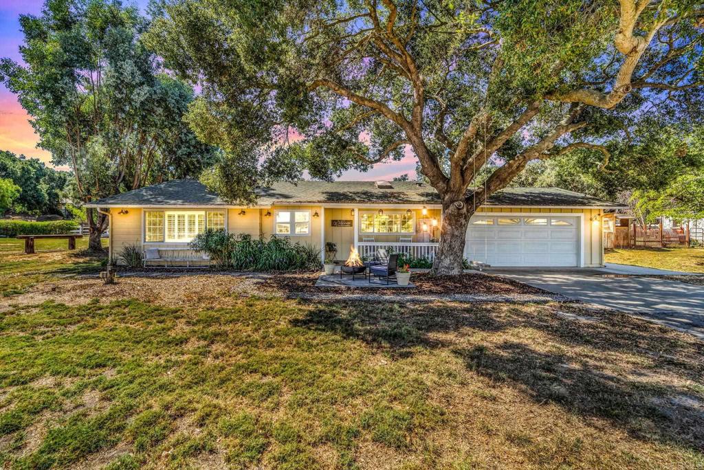 a view of a house with backyard and a tree