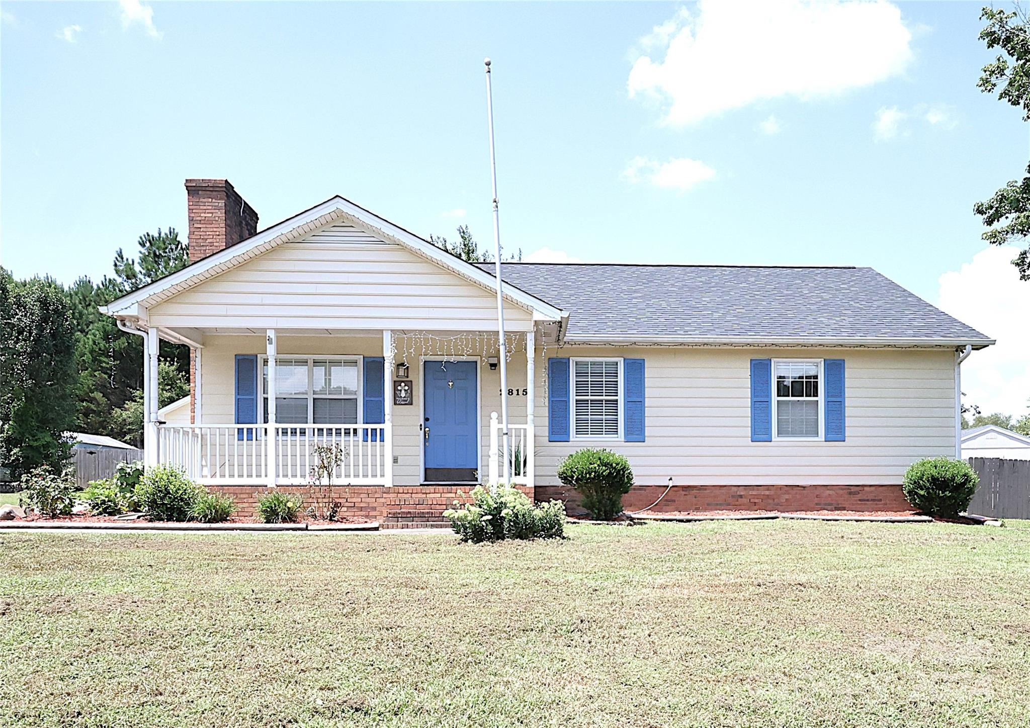 a front view of a house with a yard and potted plants