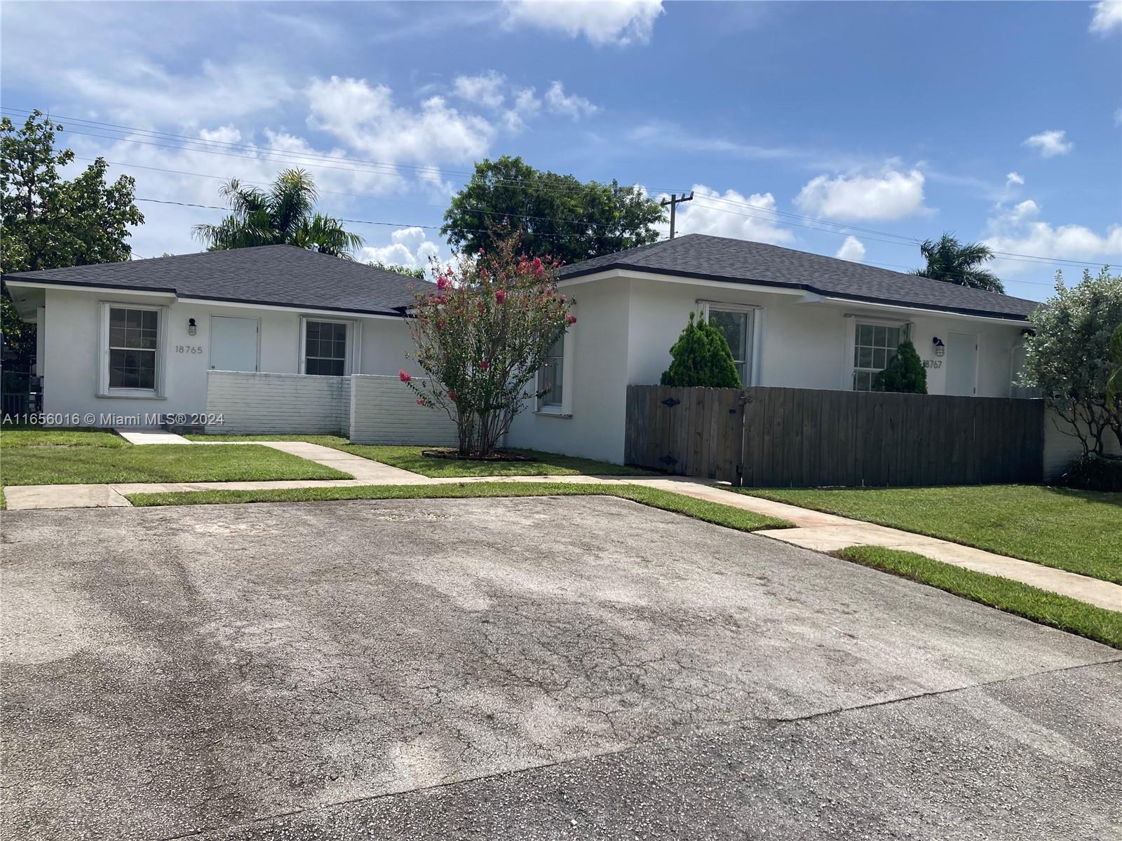 a view of a house with a yard and a large parking space