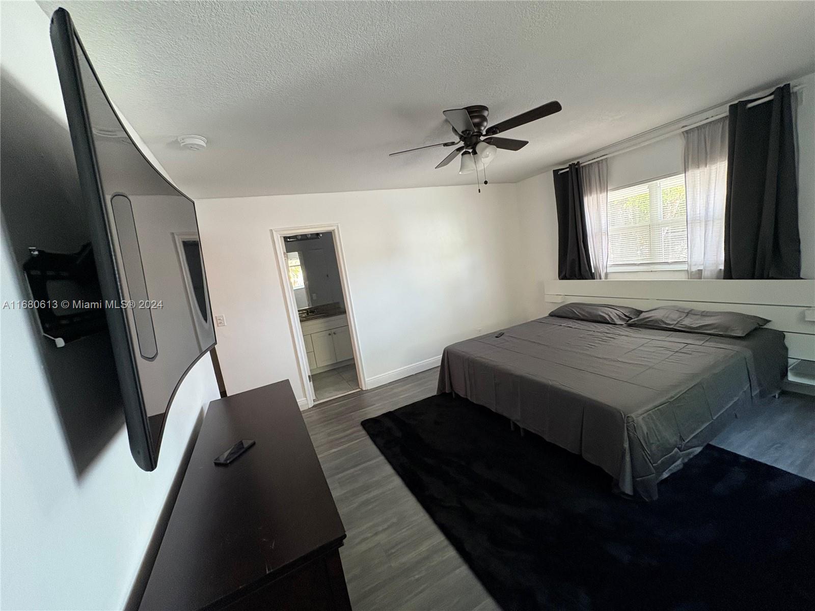 a bedroom with a bed and a large mirror next to a window