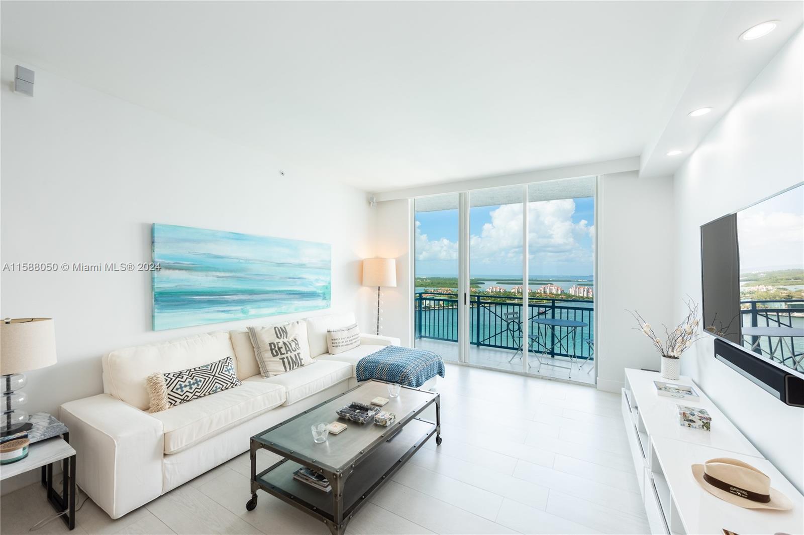 a living room with furniture a flat screen tv and a floor to ceiling window