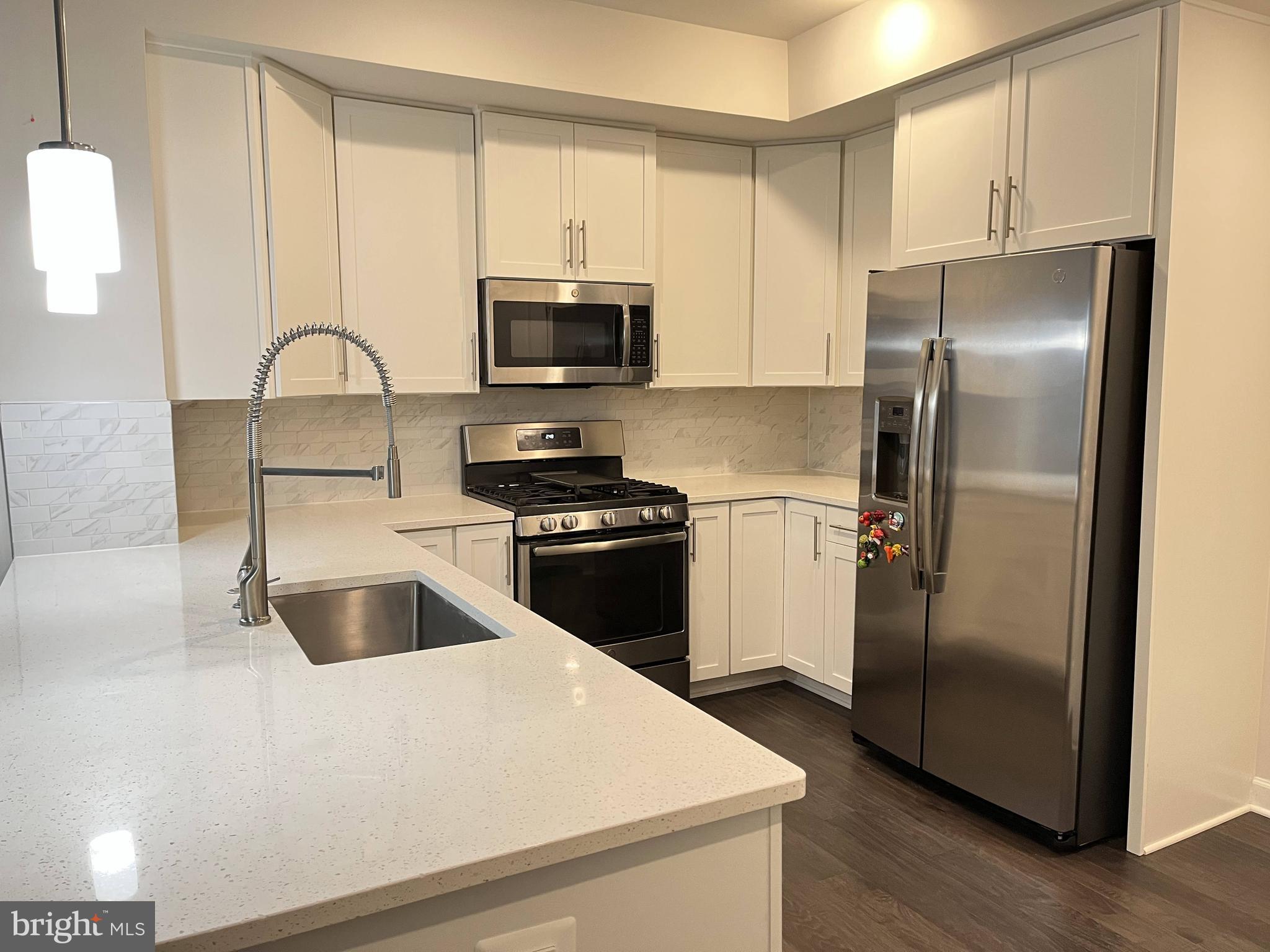 a kitchen with a refrigerator sink and cabinets