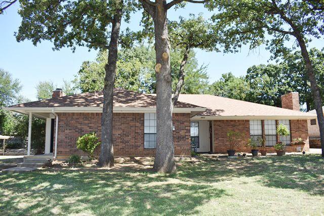 a view of a house with a tree in front of it