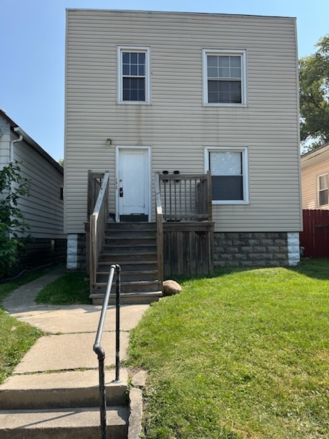 a view of house with wooden deck and a yard