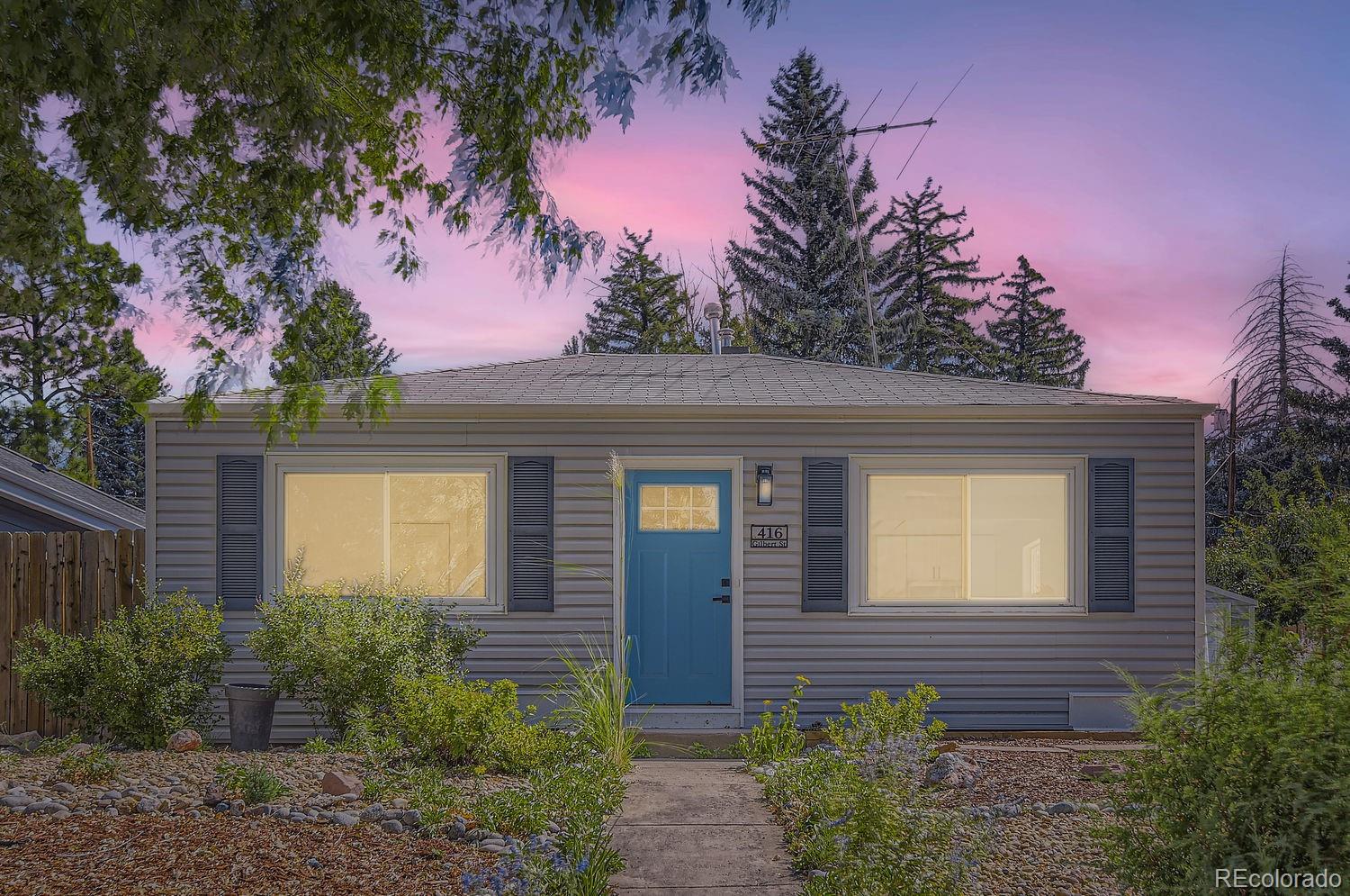 a front view of a house with yard and trees