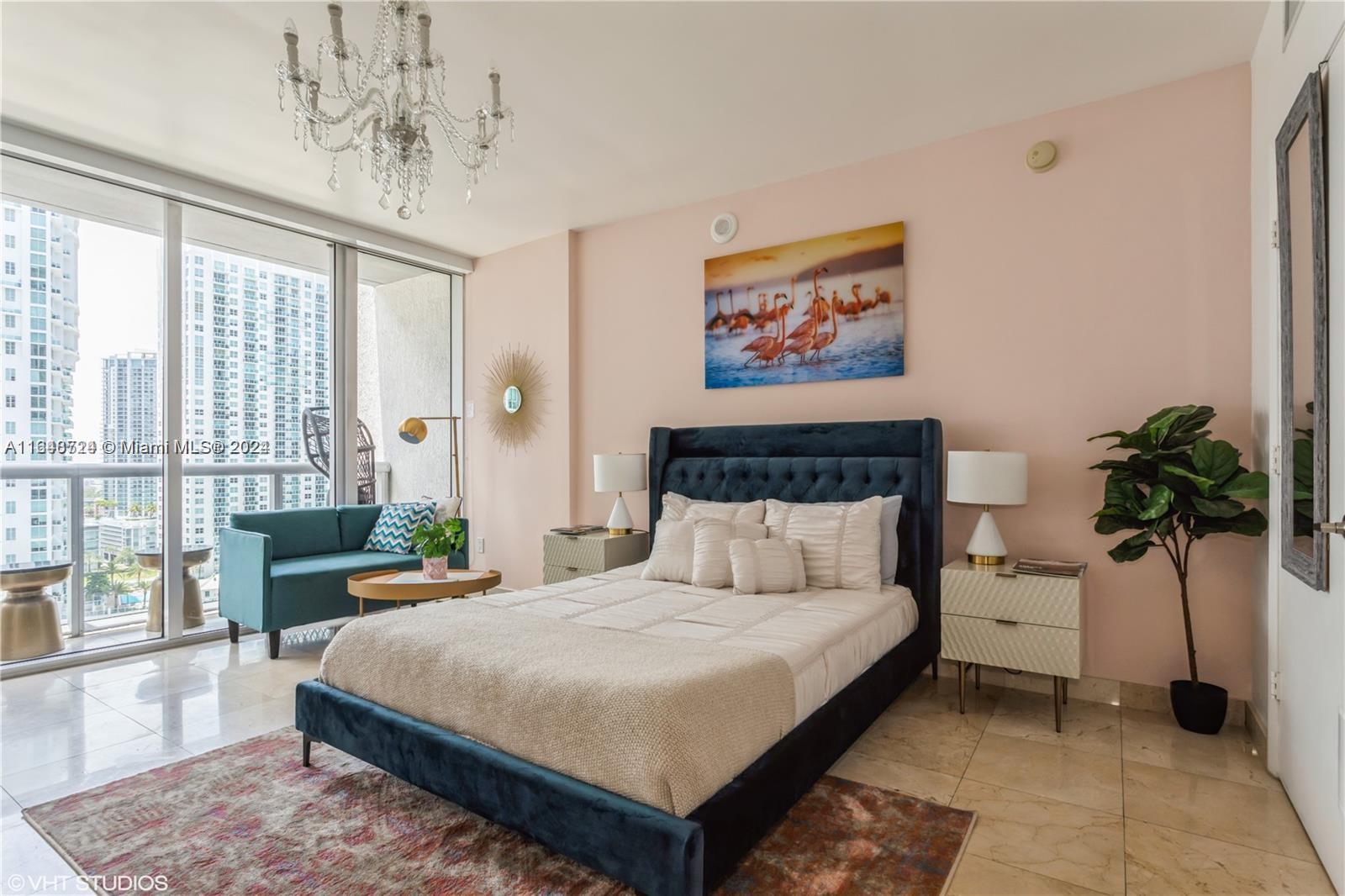 a bedroom with a large bed and a chandelier