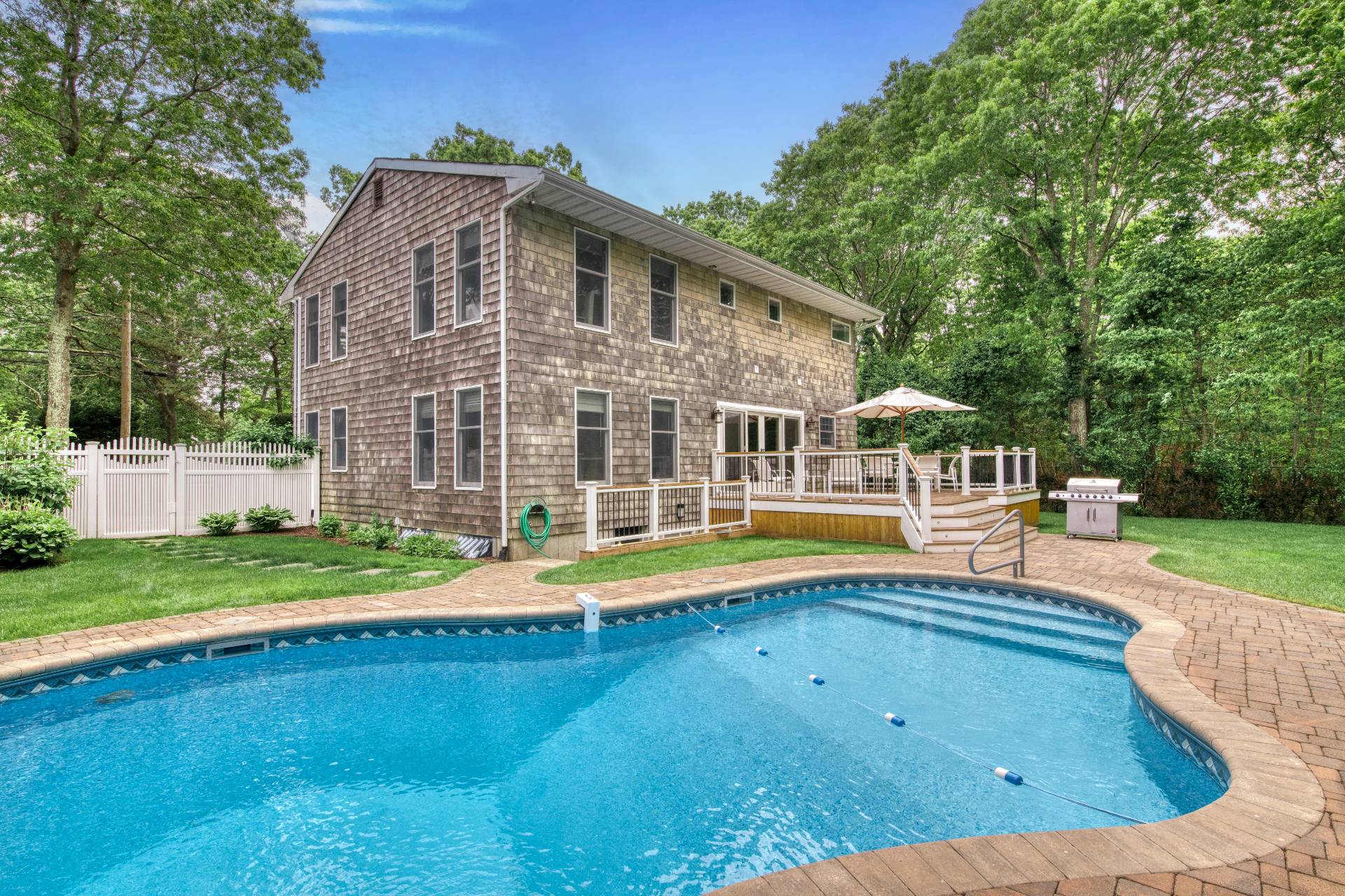 a view of a house with pool and a yard