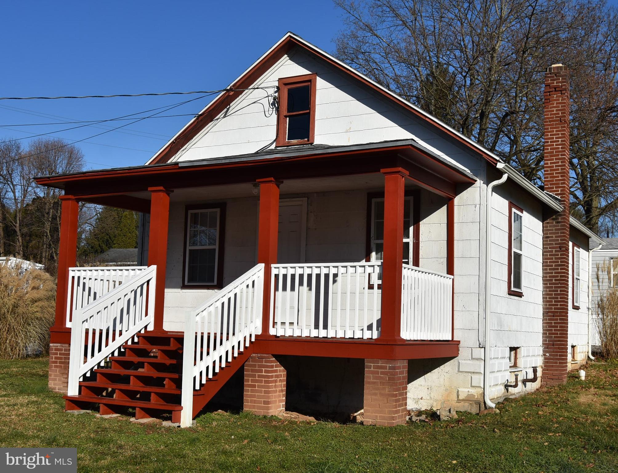 a view of a house with wooden fence and a porch