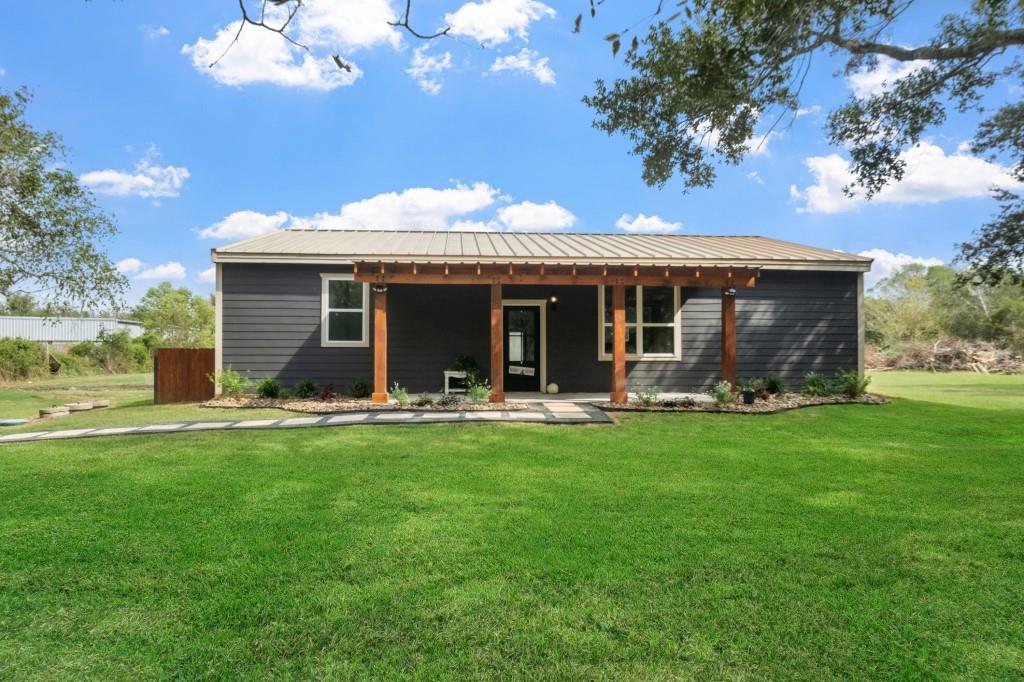 a view of a house with a yard porch and furniture