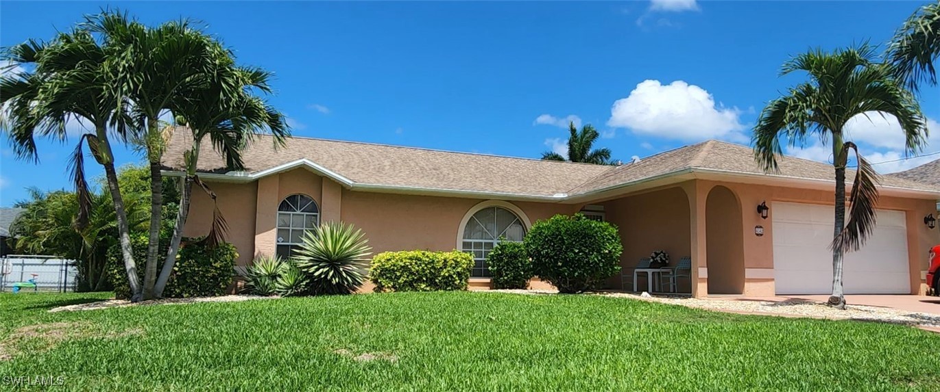 a front view of a house with a yard and potted plants