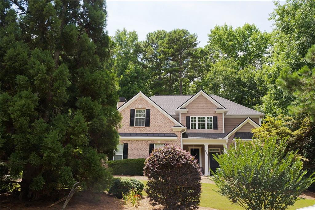 a white house with a big yard and large trees