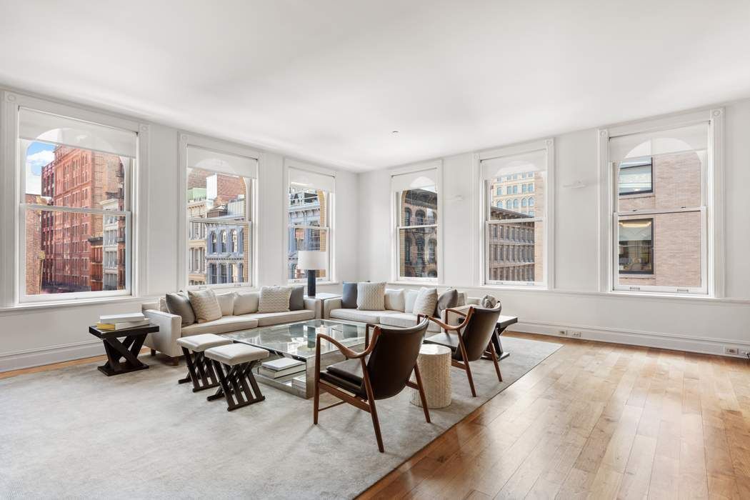 a living room with furniture and floor to ceiling windows