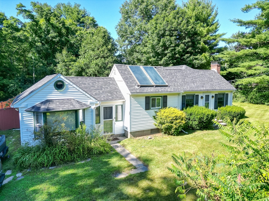 a aerial view of a house with yard and green space