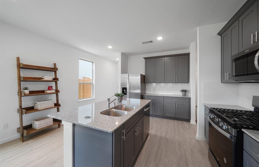 a kitchen with a sink stove and cabinets