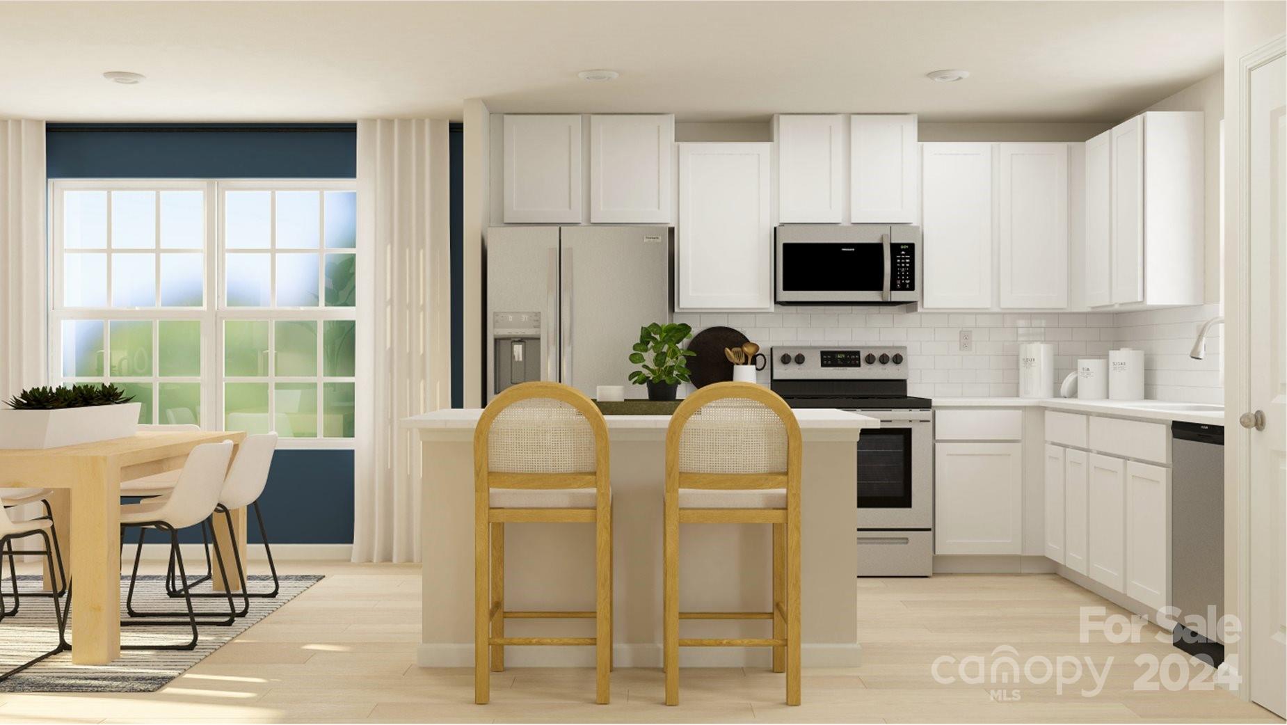 a kitchen with stainless steel appliances a stove a sink a microwave a dining table and chairs