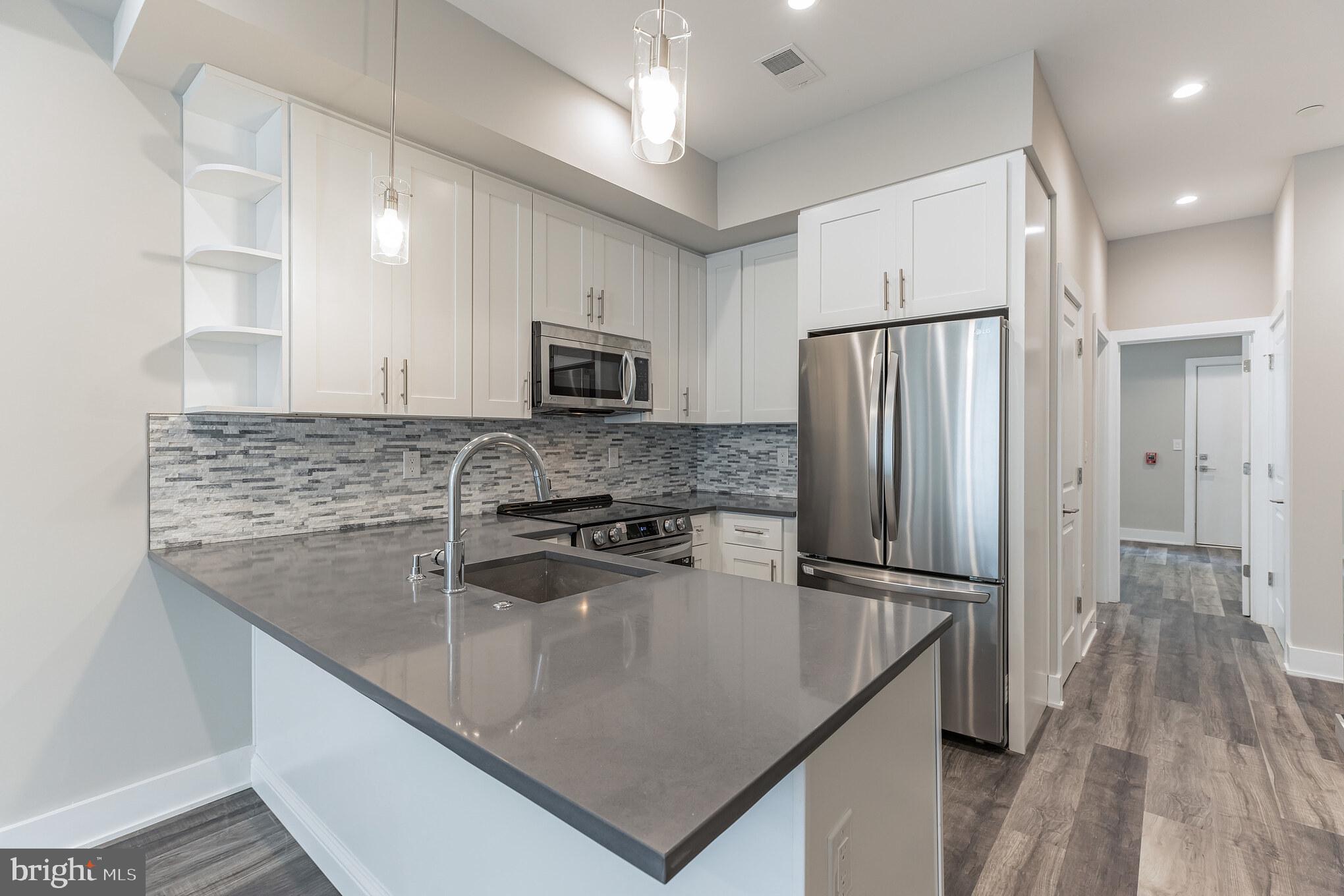 a kitchen with kitchen island a counter top space cabinets and stainless steel appliances