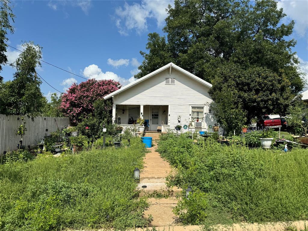 a front view of house with a garden