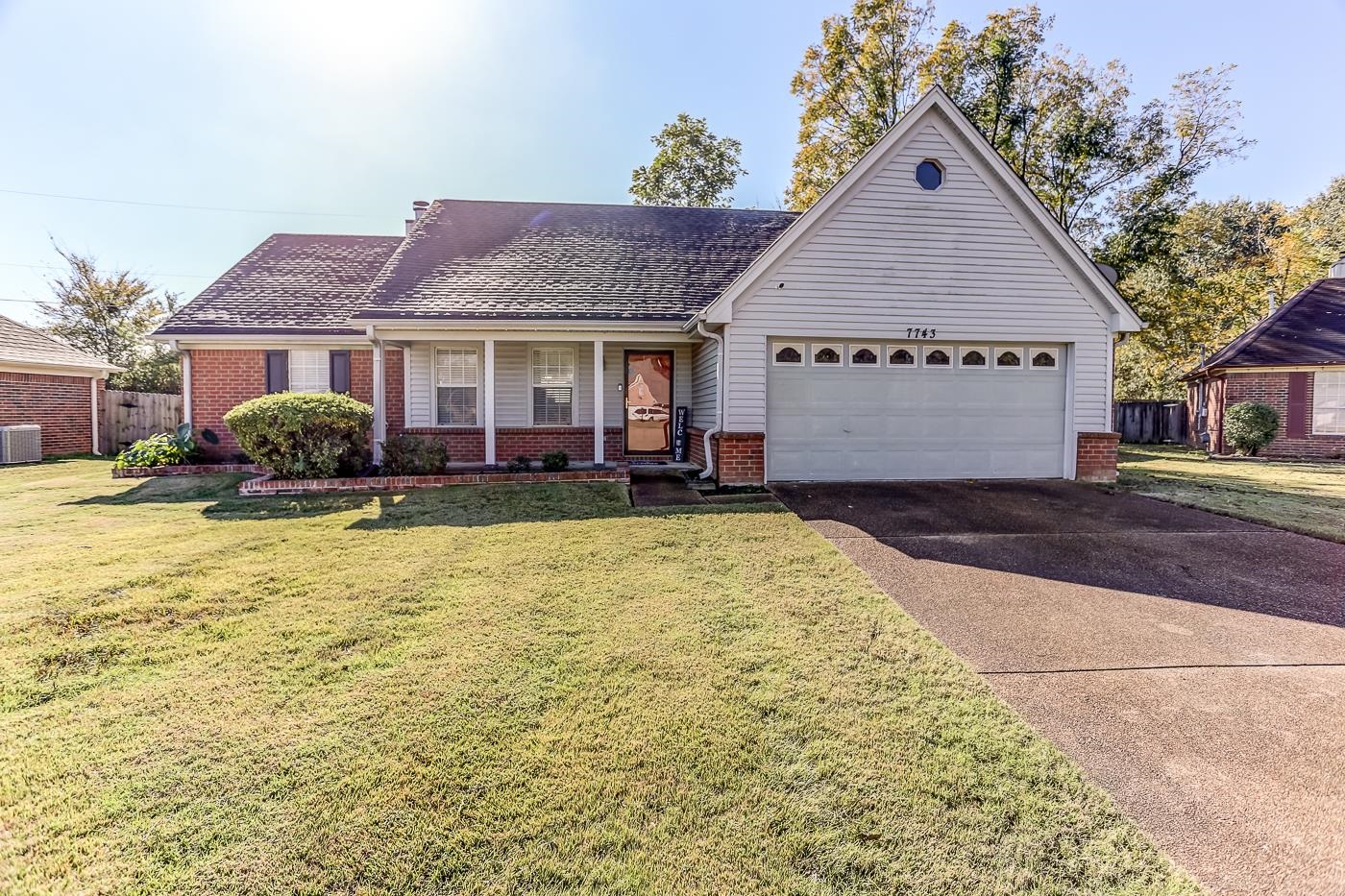 Ranch-style house with cooling unit, a garage, and a front yard