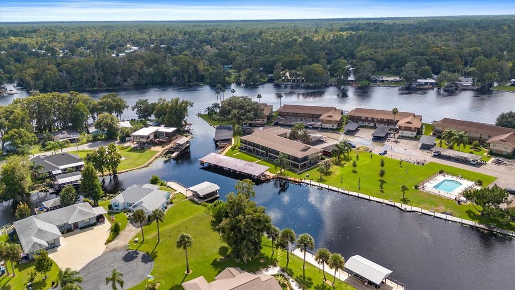 an aerial view of a house with swimming pool and lake view