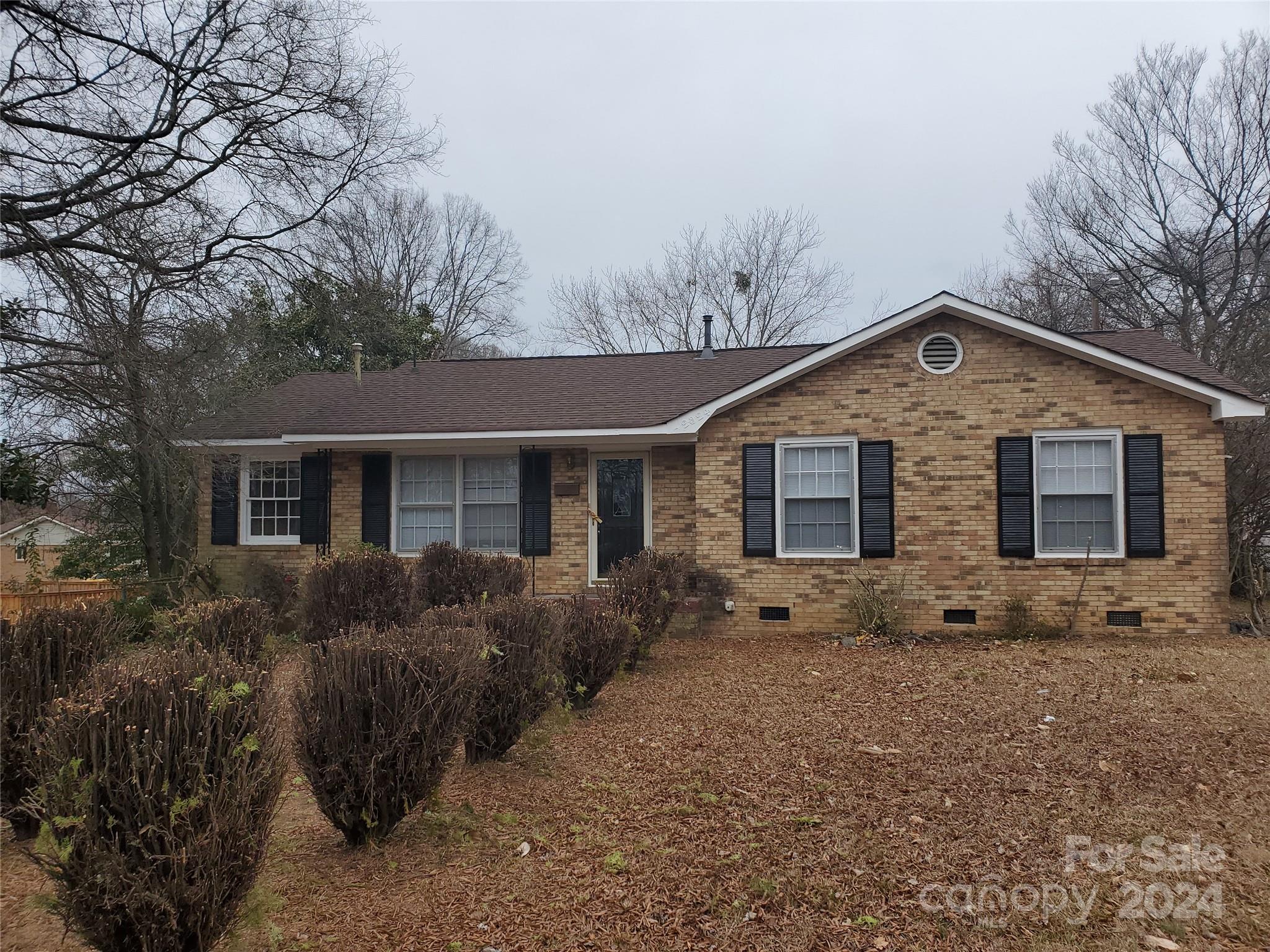 a front view of house with yard and trees in the background