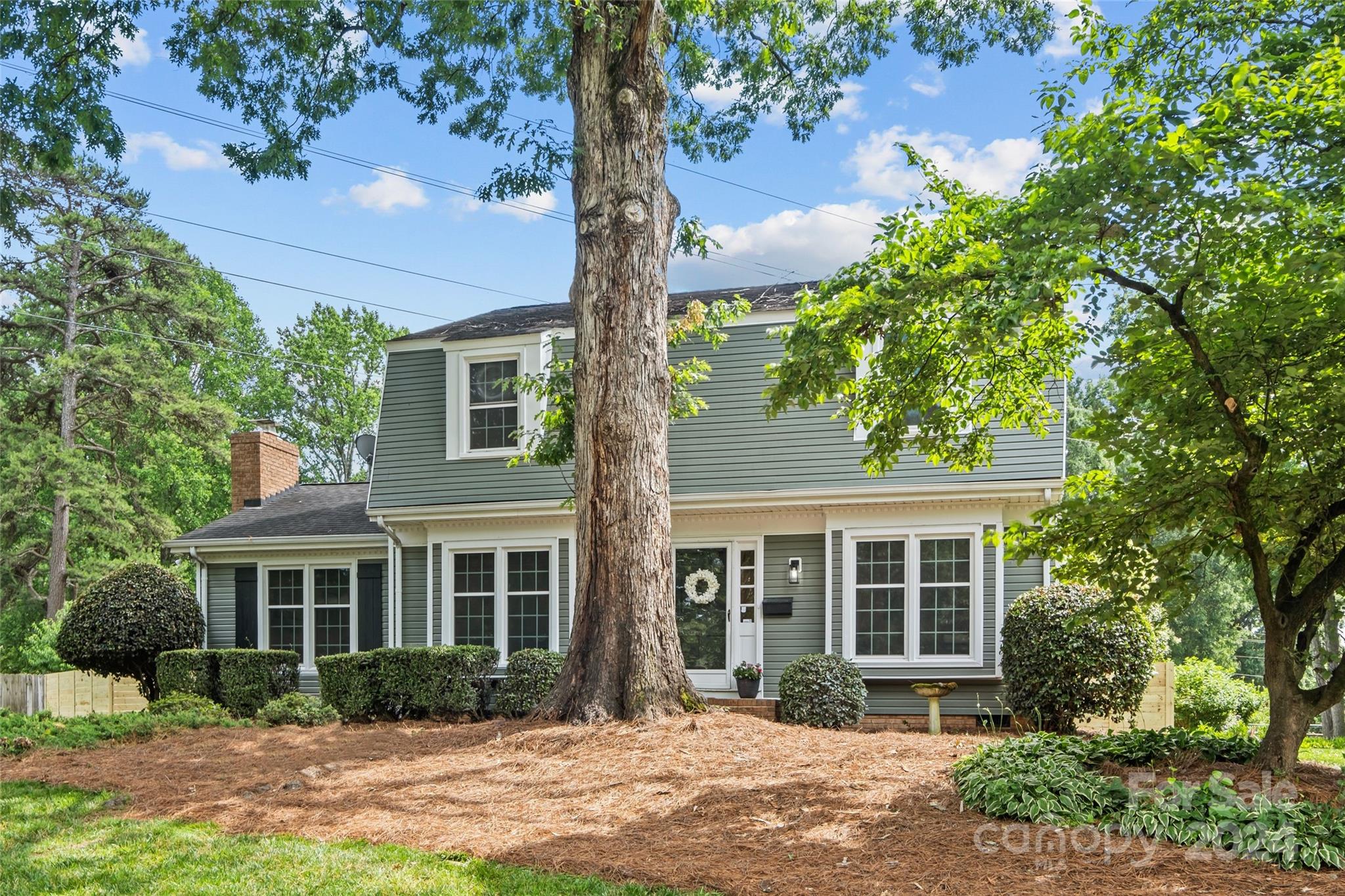 a front view of a house with a yard and potted plants