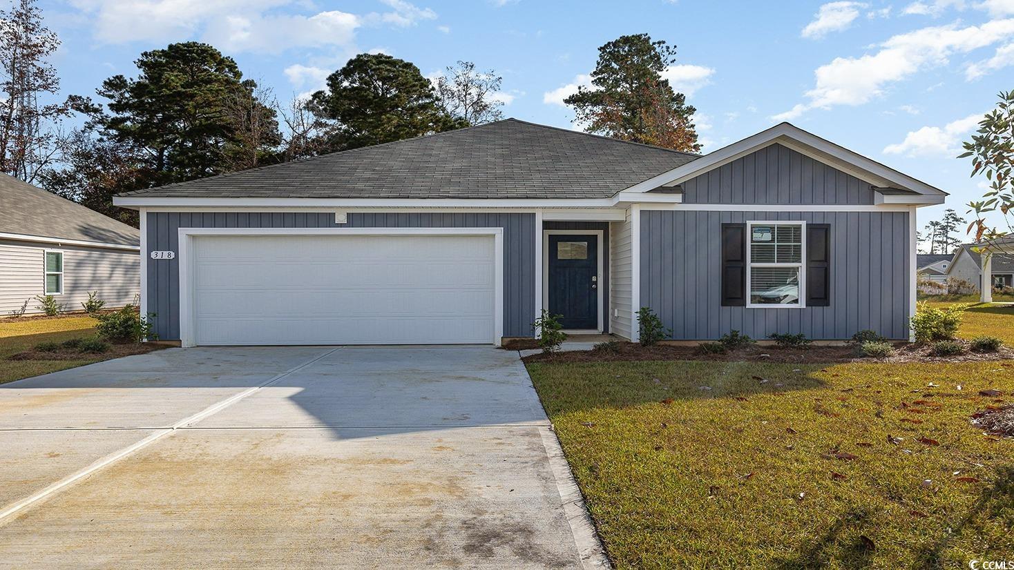 Ranch-style house with a garage and a front lawn