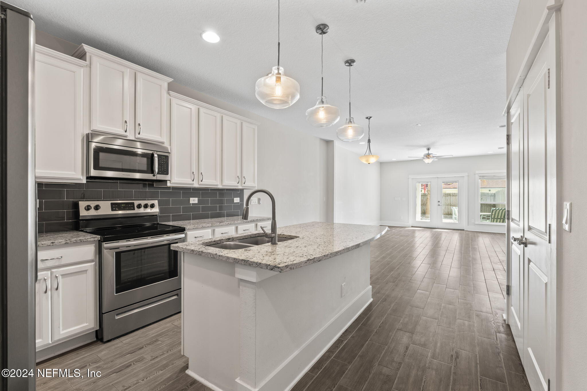 a large kitchen with granite countertop a stove and a sink