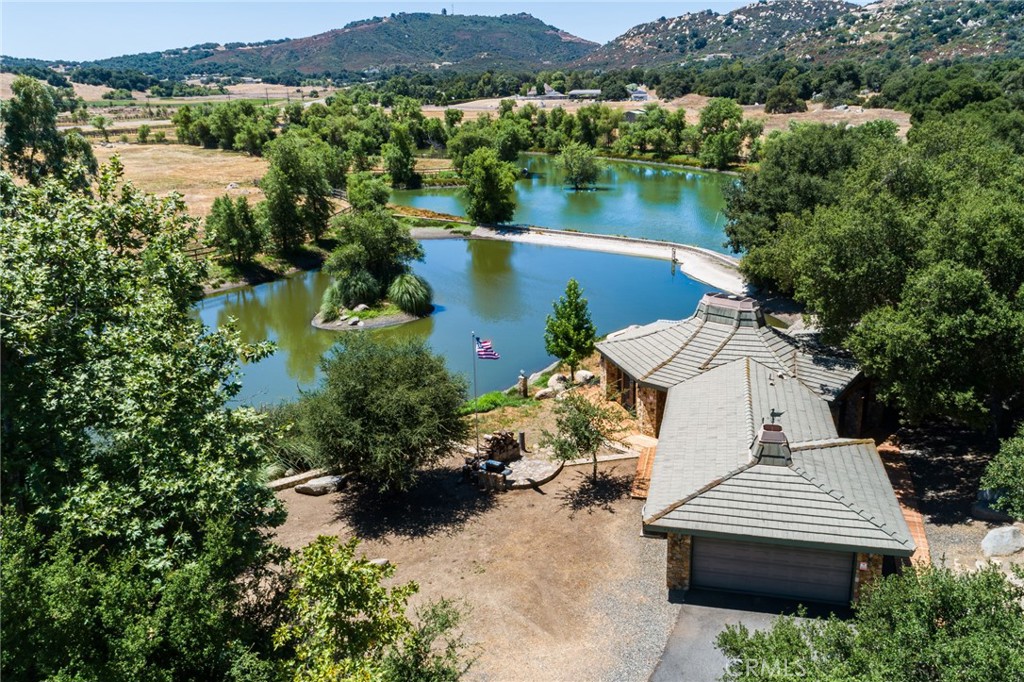 an aerial view of a house with garden space and a lake view