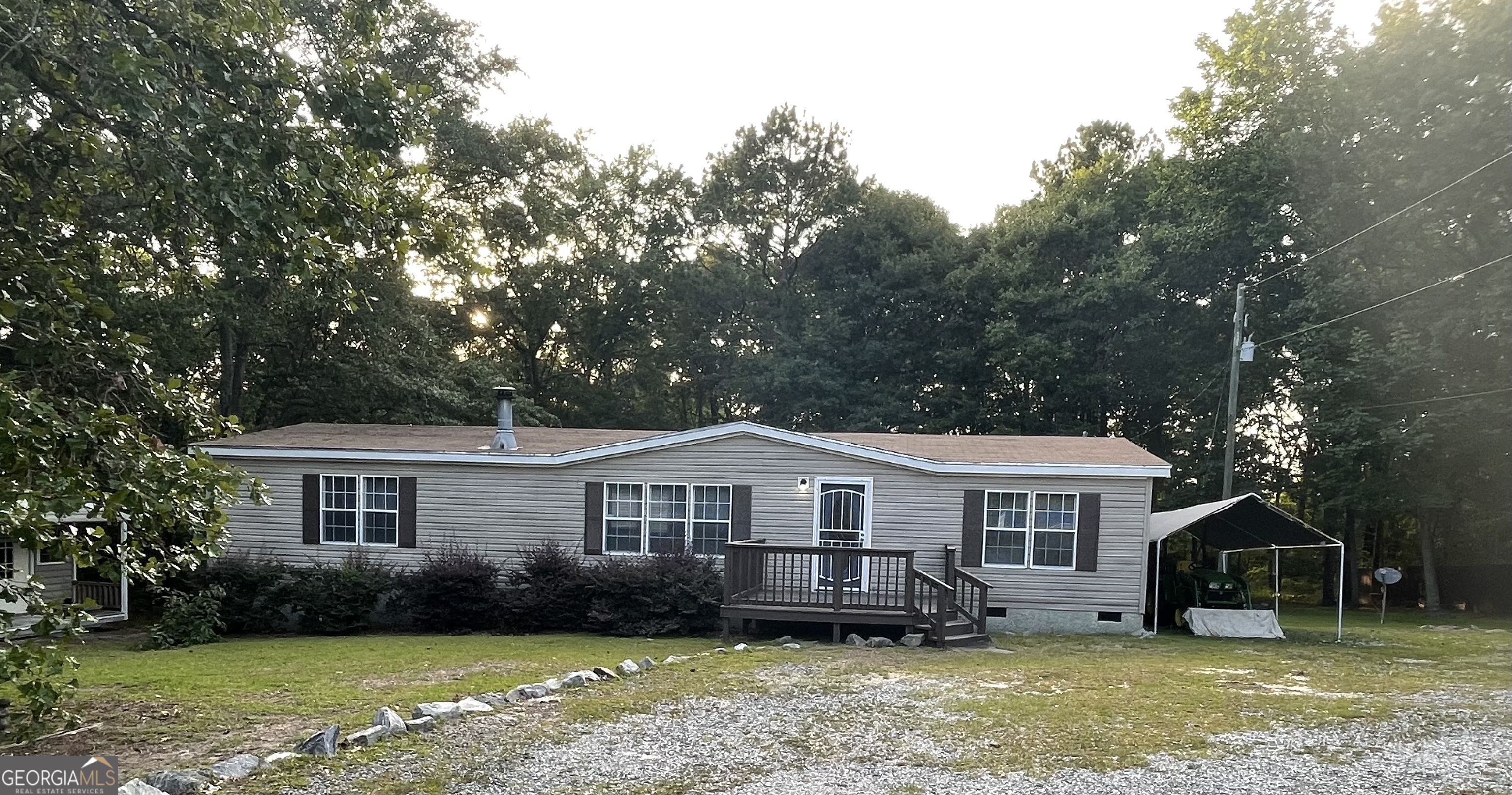 a front view of a house with a garden and trees