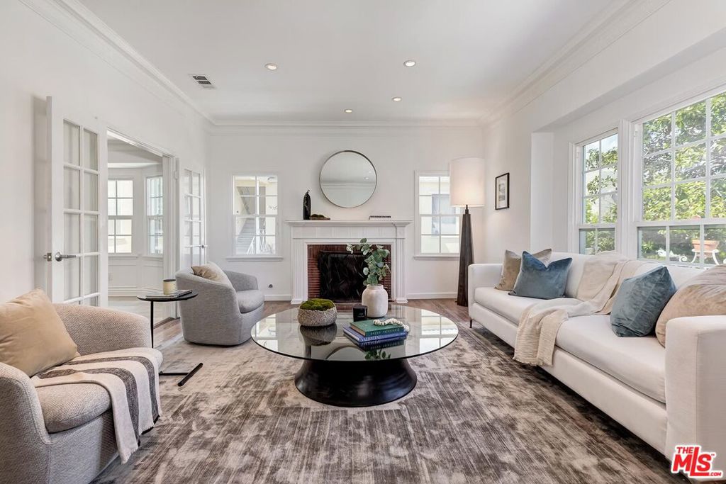 a living room with furniture a fireplace and a large window