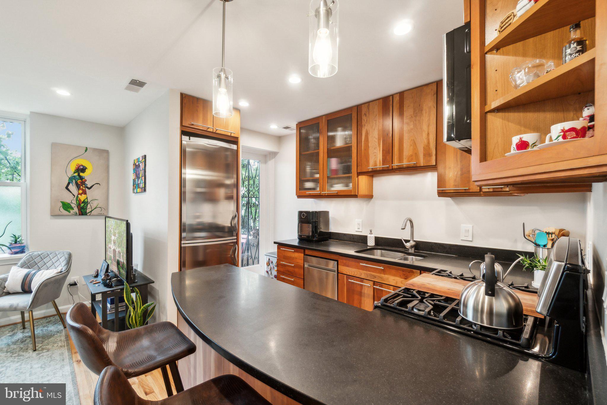 a kitchen with stainless steel appliances granite countertop a refrigerator a sink and a stove