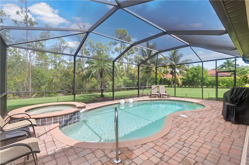 a view of swimming pool with lawn chairs under an umbrella