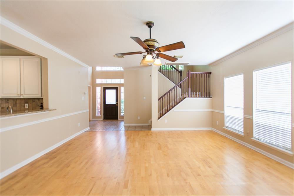 a view of a livingroom with wooden floor and a ceiling fan