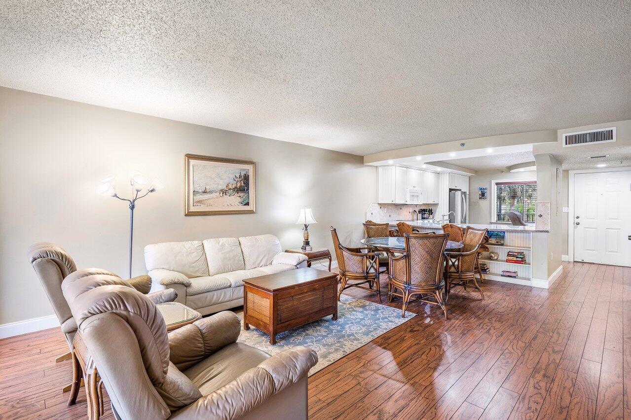 a living room with furniture wooden floor and a view of kitchen