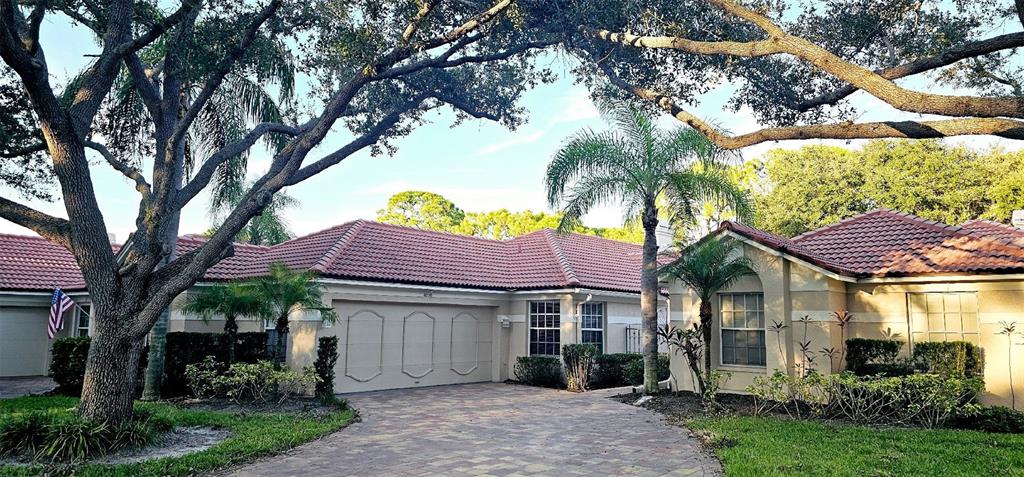 a front view of a house with a garden and trees