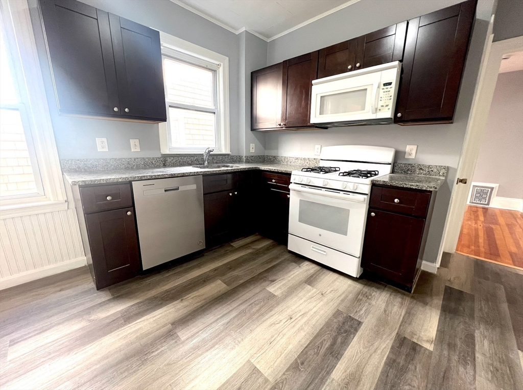 a kitchen with stainless steel appliances granite countertop a stove a sink and a microwave