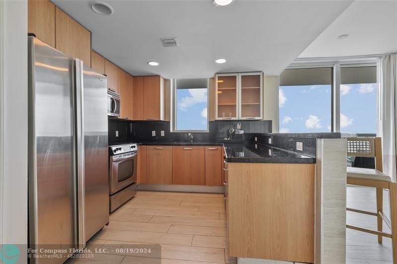 a kitchen with stainless steel appliances granite countertop a refrigerator and a sink