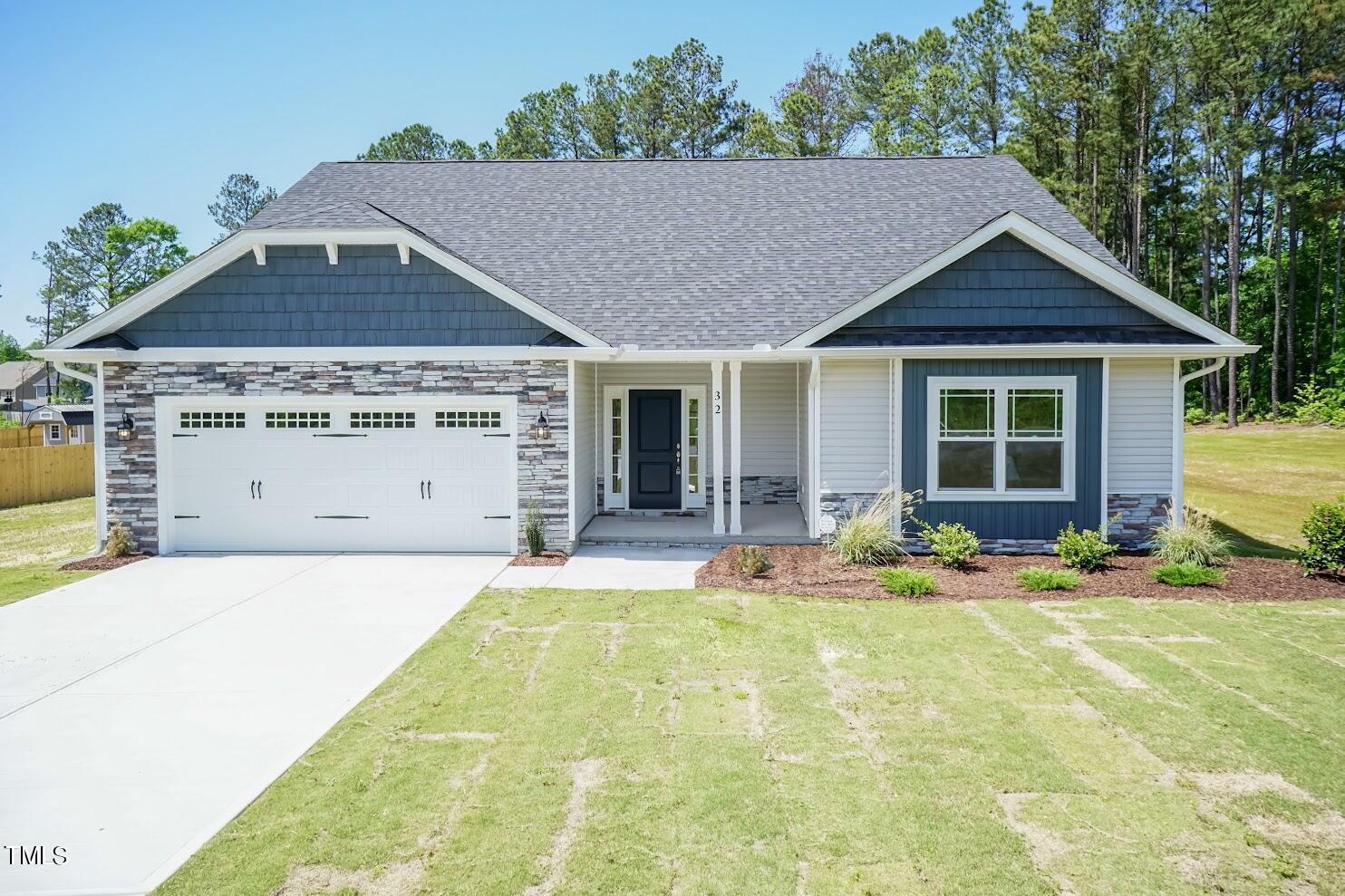 a front view of a house with a yard outdoor seating and garage