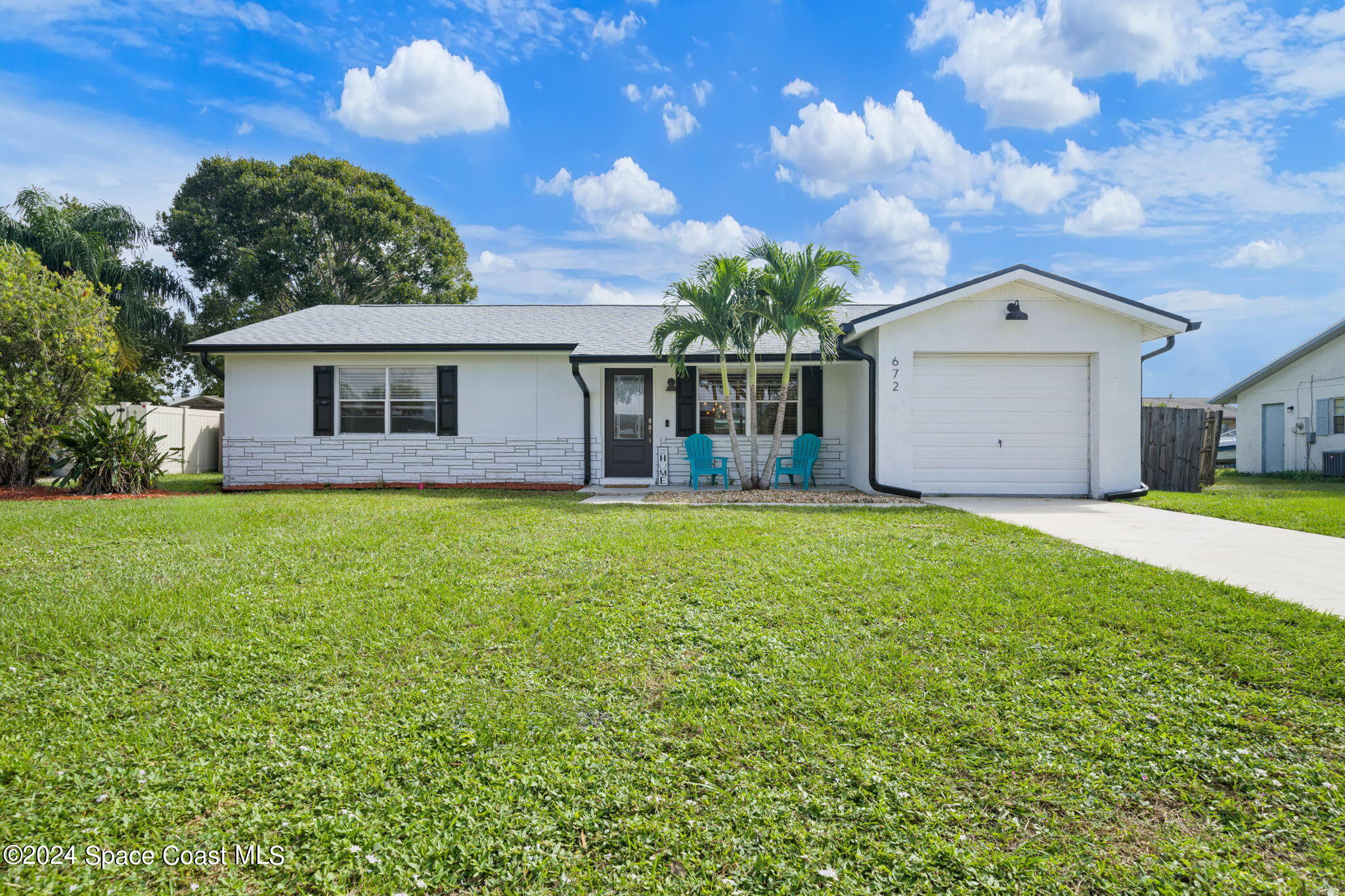 a front view of a house with yard and green space