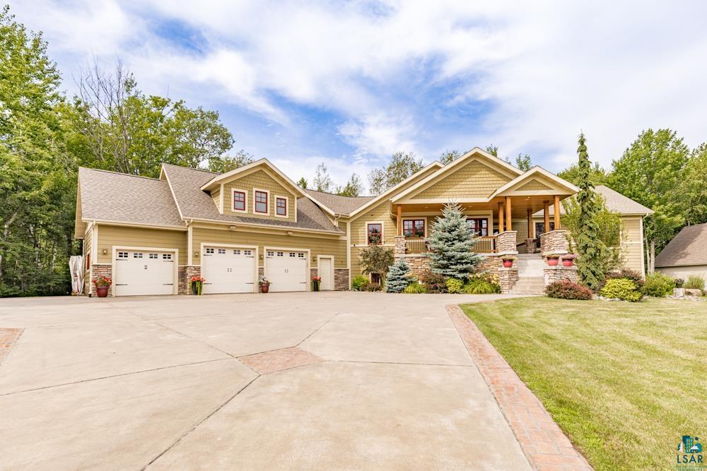 Craftsman-style home with a garage, covered porch, and a front lawn