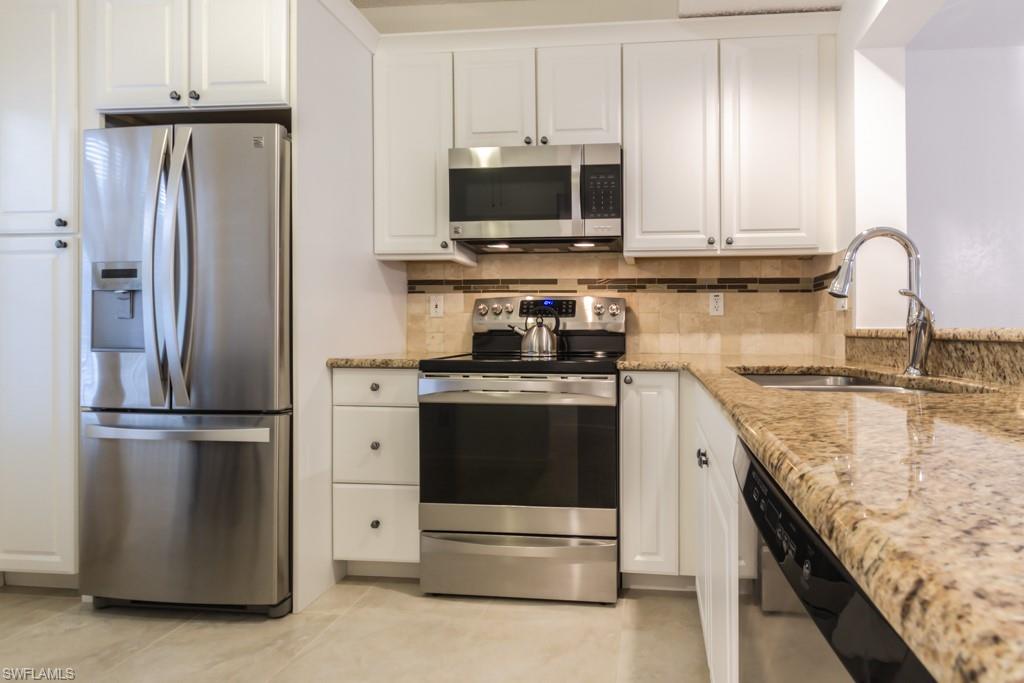 a kitchen with stainless steel appliances granite countertop a refrigerator stove and microwave