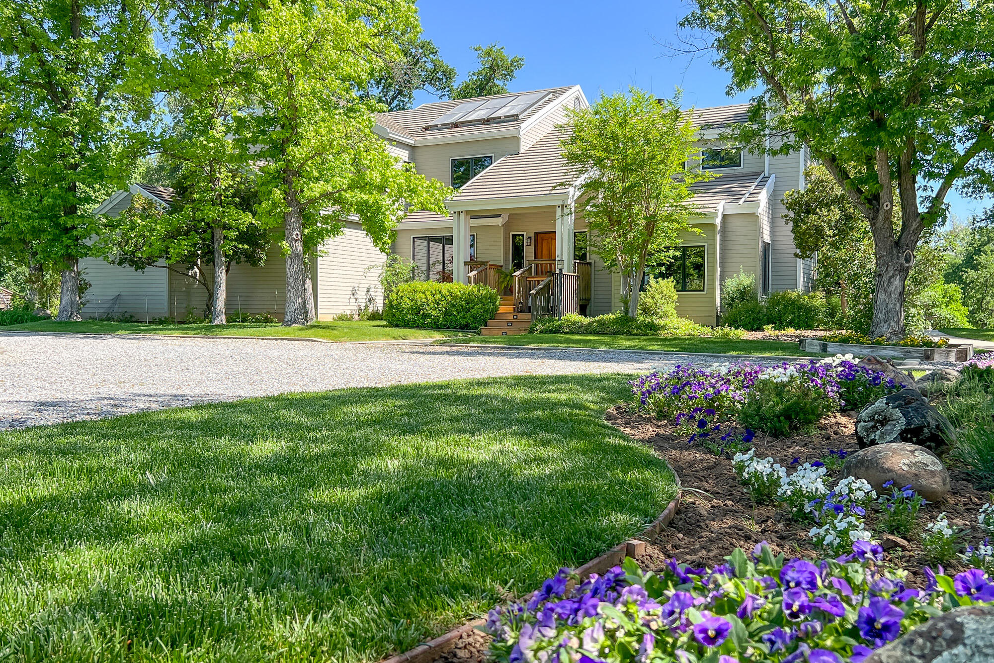 a front view of a house with a big yard and fountain