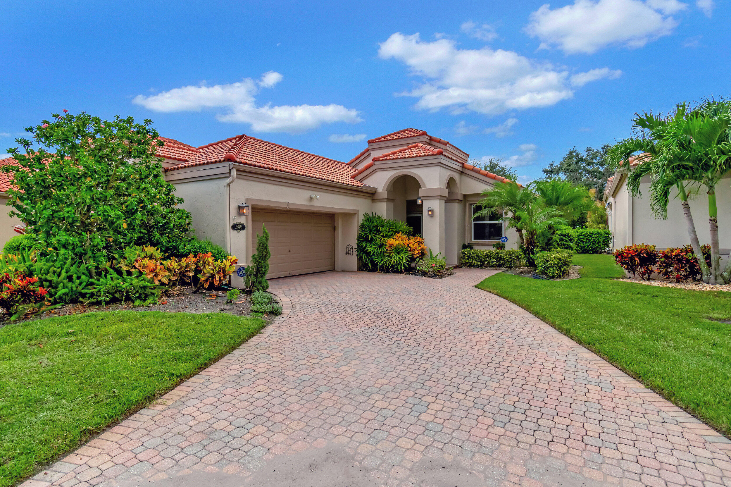 a front view of a house with a yard and potted plants