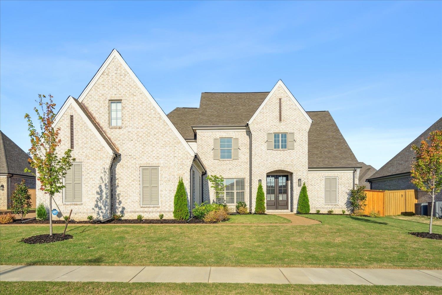 French country inspired facade featuring a front lawn and central air condition unit